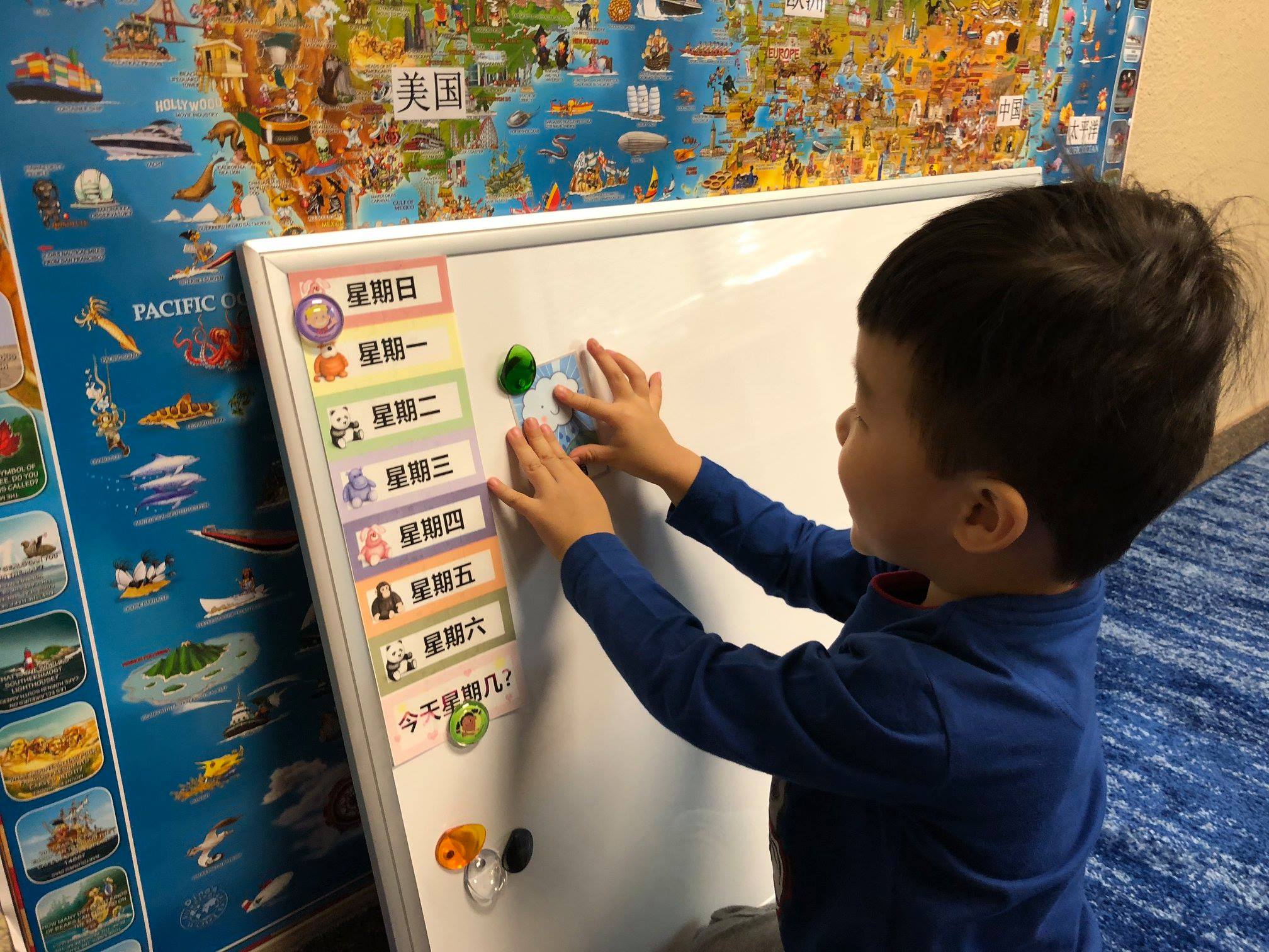 Child putting a picture on a whiteboard.